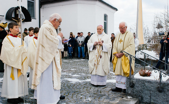 V. l.: Pfarrer Johann Schimmerl, Bischof em. Maximilian Aichern und Pater Alois Bachinger mit der Pfarrbevölkerung auf dem Kirchenplatz.