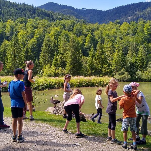 Mütter und Kinder am Bach