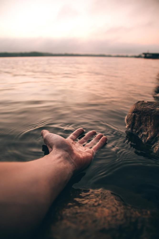 Arm ausgestreckt ins Wasser