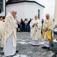 V. l.: Pfarrer Johann Schimmerl, Bischof em. Maximilian Aichern und Pater Alois Bachinger mit der Pfarrbevölkerung auf dem Kirchenplatz.