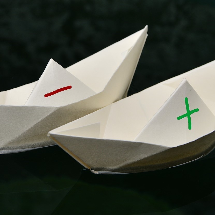 Papierschiffchen mit Plus und Minus