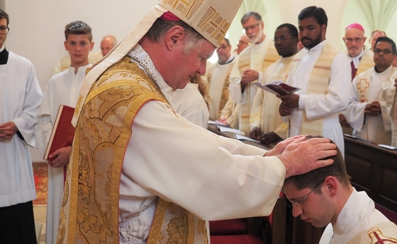 Bischof Manfred Scheuer spendet Vitus Glira durch Handauflegung das Sakrament der Priesterweihe.