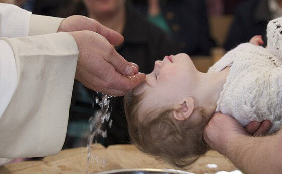Ein Kind empfängt die Taufe.