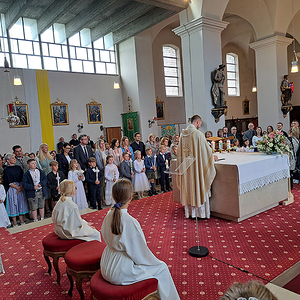 Die Taufpaten stellen sich mit den Taufkerzen hinter die Kinder