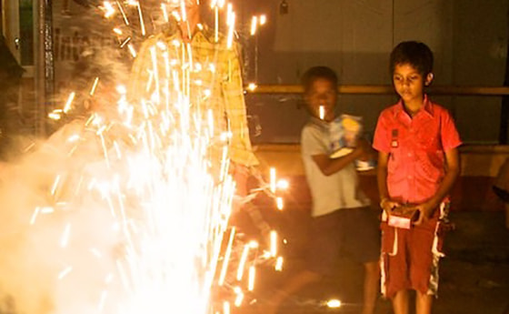 Indische Kinder beim Zünden eines Feuerwerkes 