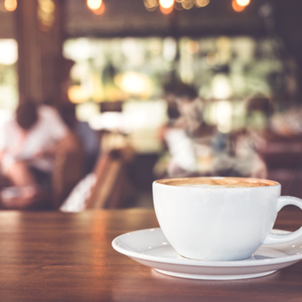Cup of hot coffee on table in cafe with people. vintage and retro color effect - shallow depth of field