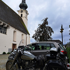 Autos und Zweiräder vor der Kirche