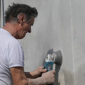 Hans schleift das neue Mauerwerk.