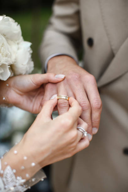 The bride wears a ring to the groom at the wedding ceremony