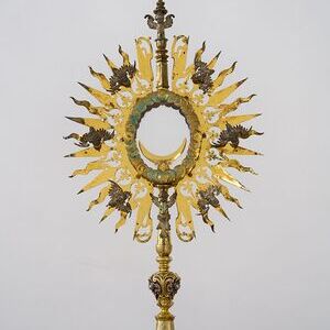 Die Monstranz  stammt aus der Zeit 1630-1640 und ist Silber vergoldet. Hinweis auf die Datierung ist das Augsburger Beschauzeichen 'GE' (Georg Ernst). Ihre Besonderheit ergibt sich durch die Gestaltung mit Cheruben, Engeln, die in der biblischen Über