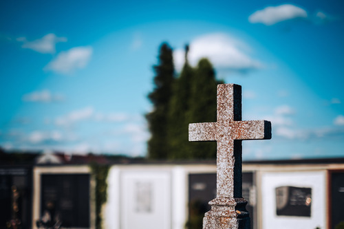 Steinkreuz in einem Friedhof.