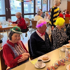 verkleidete Personen sitzen beim gedeckter Tisch