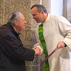 Seelsorger Dominik Stockinger überreicht die Urkunde