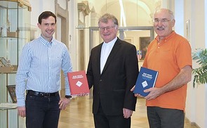 Franz Kogler und sein Nachfolger Reinhard Stiksel vom Bibelwerk Linz übergeben das Neue Testament an Bischof Manfred Scheuer