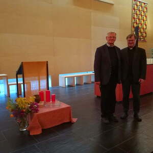 Bischof und Pfarrer vor dem Altar