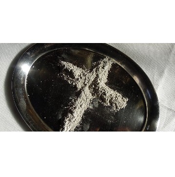 auf einem silbernen Tablett ist ein Kreuz, gestreut aus Asche