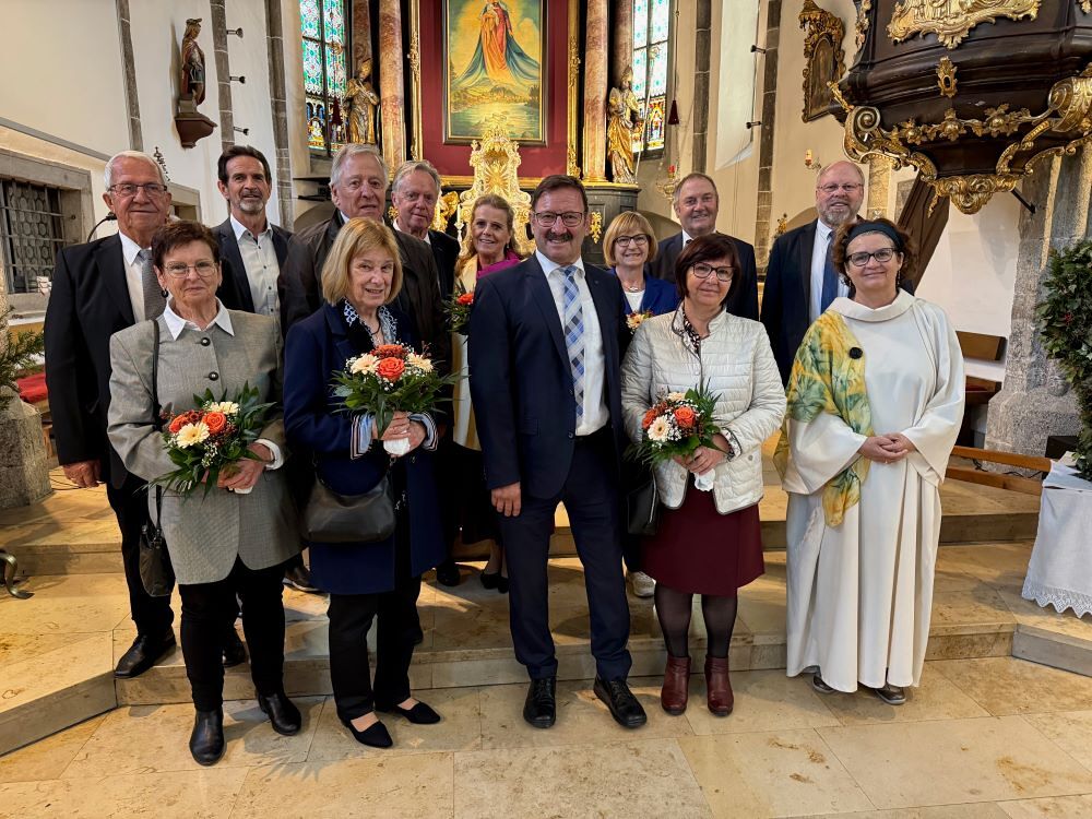 Gruppe mit Personen und Blumensträußen in einer Kirche