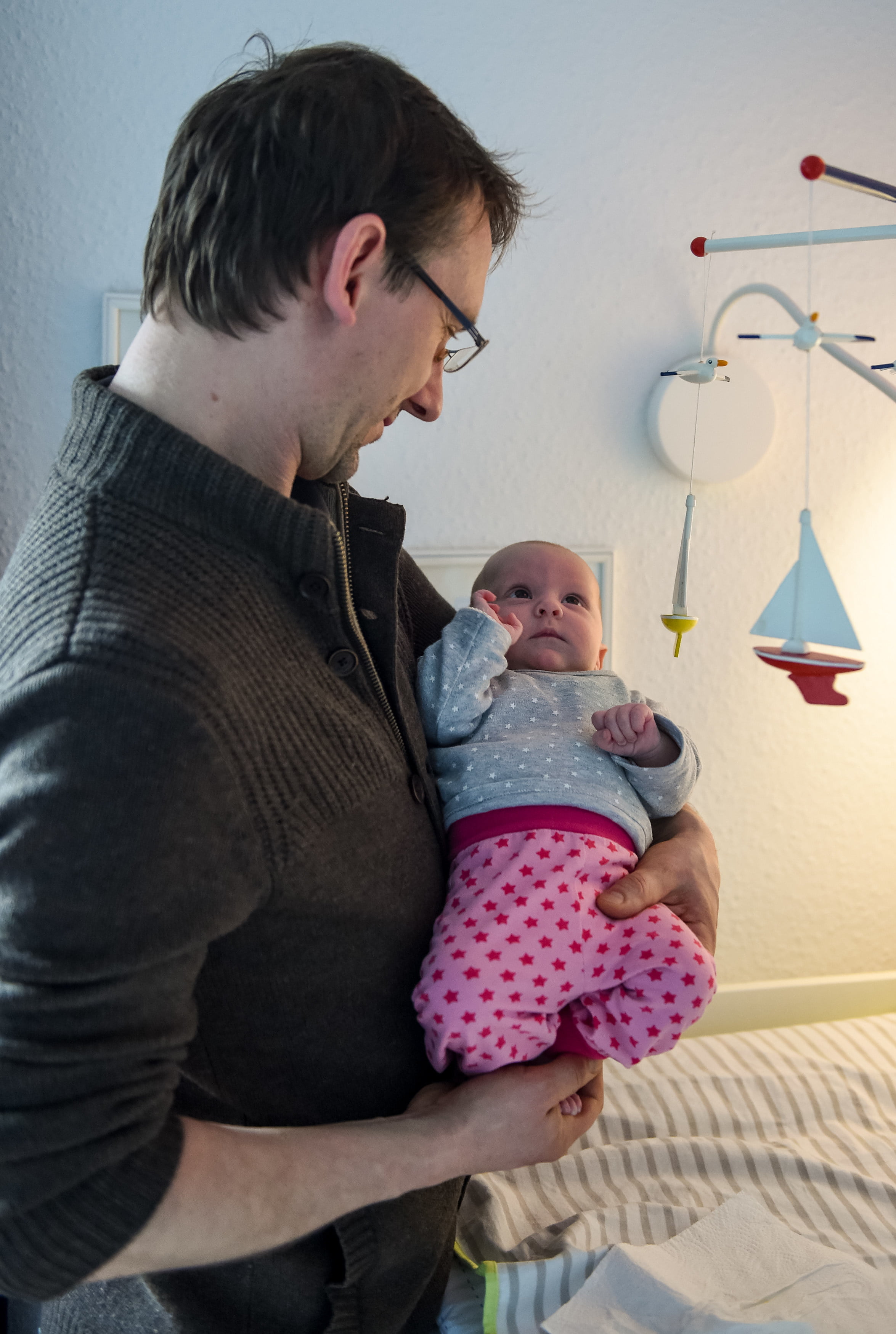 Ein Vater hält seine Tochter auf dem Arm.