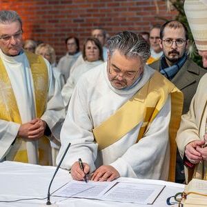 Pastoralvorstand Christian Landl unterzeichnet das Glaubensbekenntnis, neben ihm Pfarrer Janusz Zaba (l.) und Bischof Manfred Scheuer.