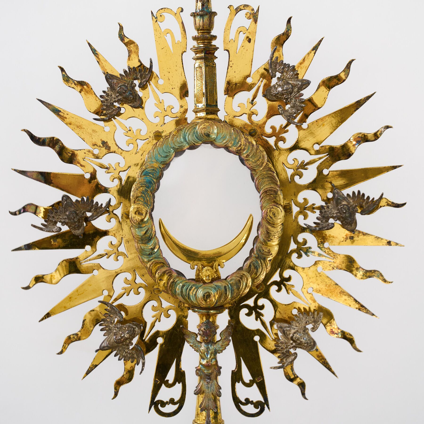 Die Monstranz  stammt aus der Zeit 1630-1640 und ist Silber vergoldet. Hinweis auf die Datierung ist das Augsburger Beschauzeichen 'GE' (Georg Ernst). Ihre Besonderheit ergibt sich durch die Gestaltung mit Cheruben, Engeln, die in der biblischen Über
