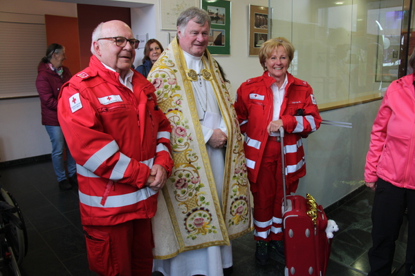 Mitarbeiter vom roten Kreuz mit Bischof