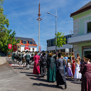 F26-06-04_4902_Goldhaubenfrauen - Kommunionkinder - Musikkapelle - Fahnentraeger vorm Ortsplatz