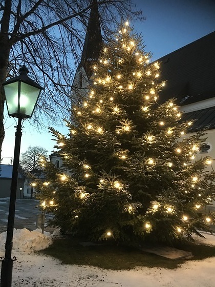 Christbaum vor Kirche erstrahlt in hellem Glanz