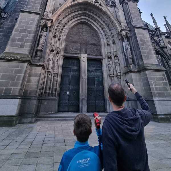 Ein Vater mit seinem Sohn steht vor dem Seiteneingang des Domes