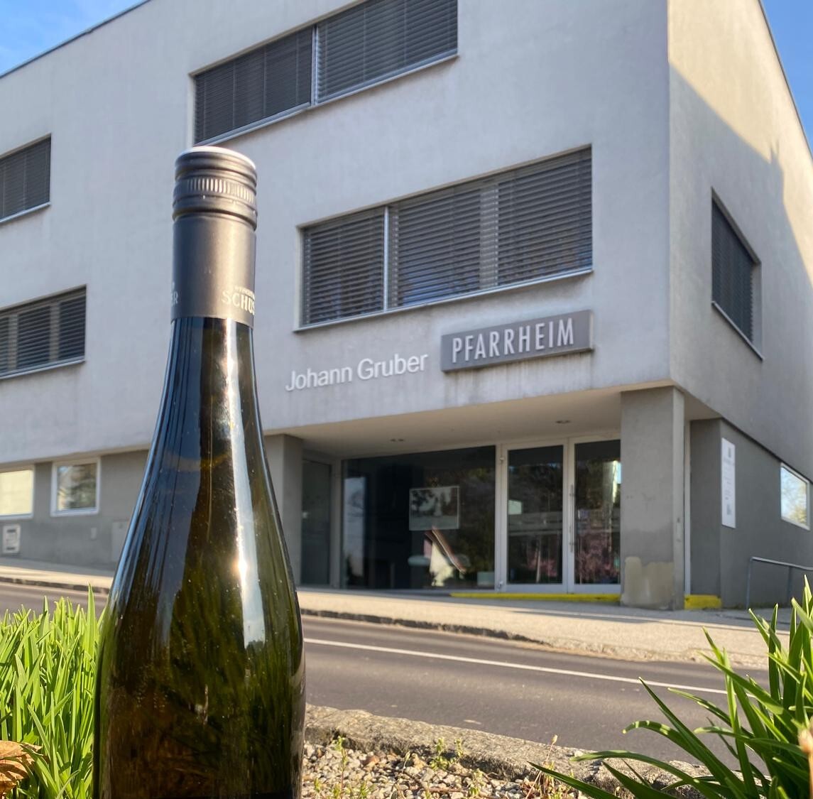 Pfarrheim mit Weinflasche