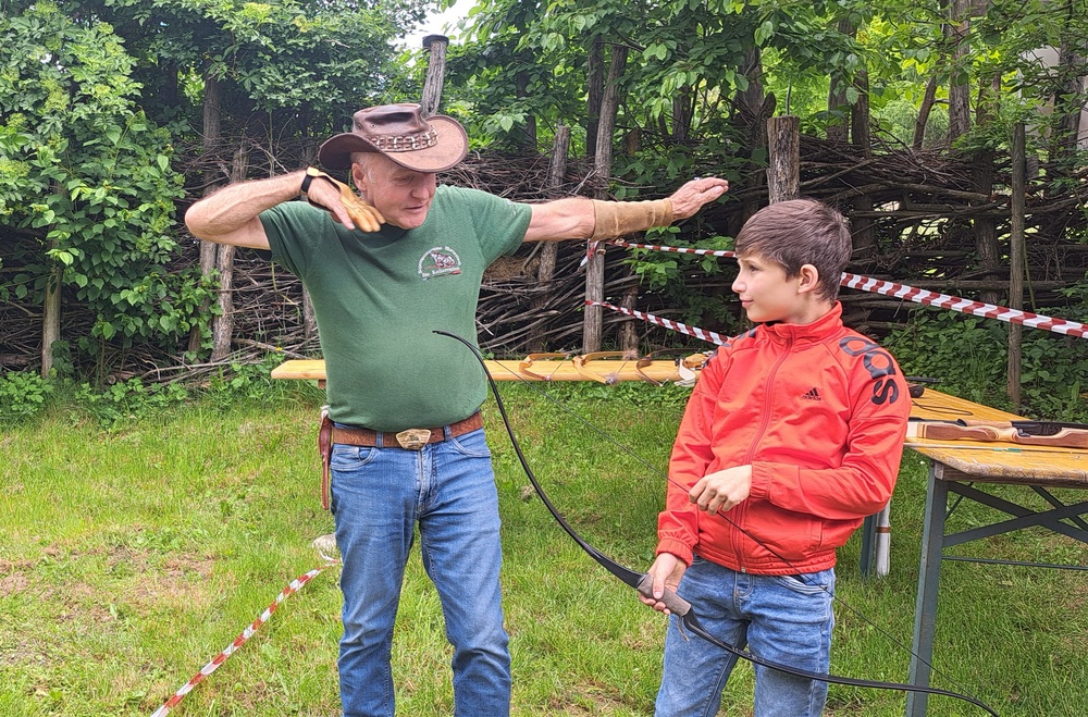 Ein Mann zeigt, wie man den Bogen richtig spannt
