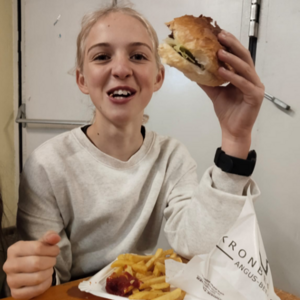 Mädchen freut sich über saftigen Burger mit Pommes