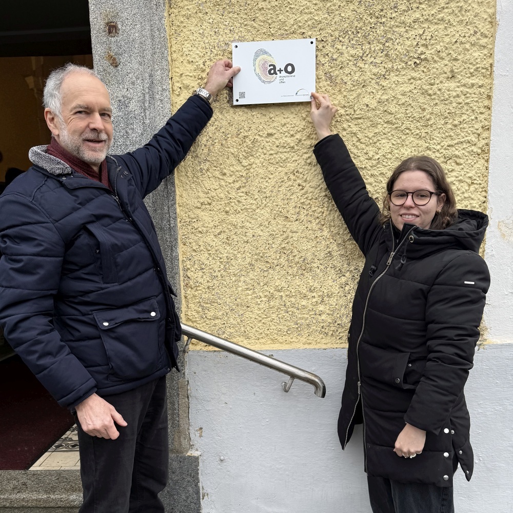 Lea Stipanitz und Günter Mahringer bringen die a&o-Plakette an