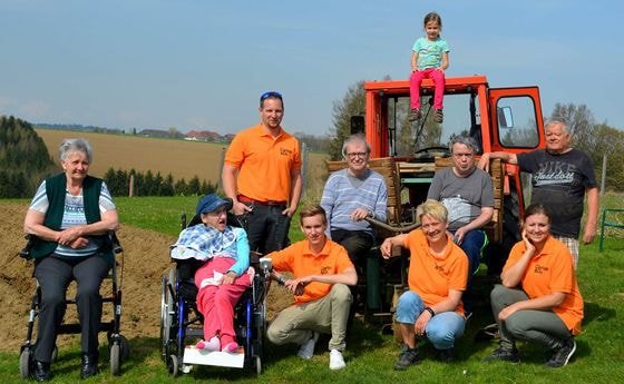 Caritas-Haustechniker Thomas Schmid (stehend, im orangen T-Shirt) mit dem 'Arbeitstrupp'.