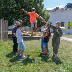 Spielerisch entdecken die Kinder zentrale Botschaften der BibelBild: Gruppe aus Kirchdorf an der Krems beim Balkenspiel. Die Kinder erleben beim Bewegen über Holzbalken: Gemeinsames Handeln, achtsames Miteinander, Vertra