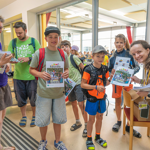 Zum Abschied erhielten die Kinder eine Kaleidio-Zeitung - eine Zusammenfassung ihrer Woche mit vielen FotosBild rechts Jana Hofer, Leiterin Bereich Öffentlichkeitsarbeit am Kaleidio 2026, verteilt die Zeitung an die Gruppe aus Kirchdorf an 