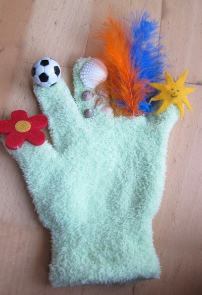 grüner Handschuh auf den Spitzen kleben: gelb, blau, orange Federn, Watte, Fußball, rote Blume