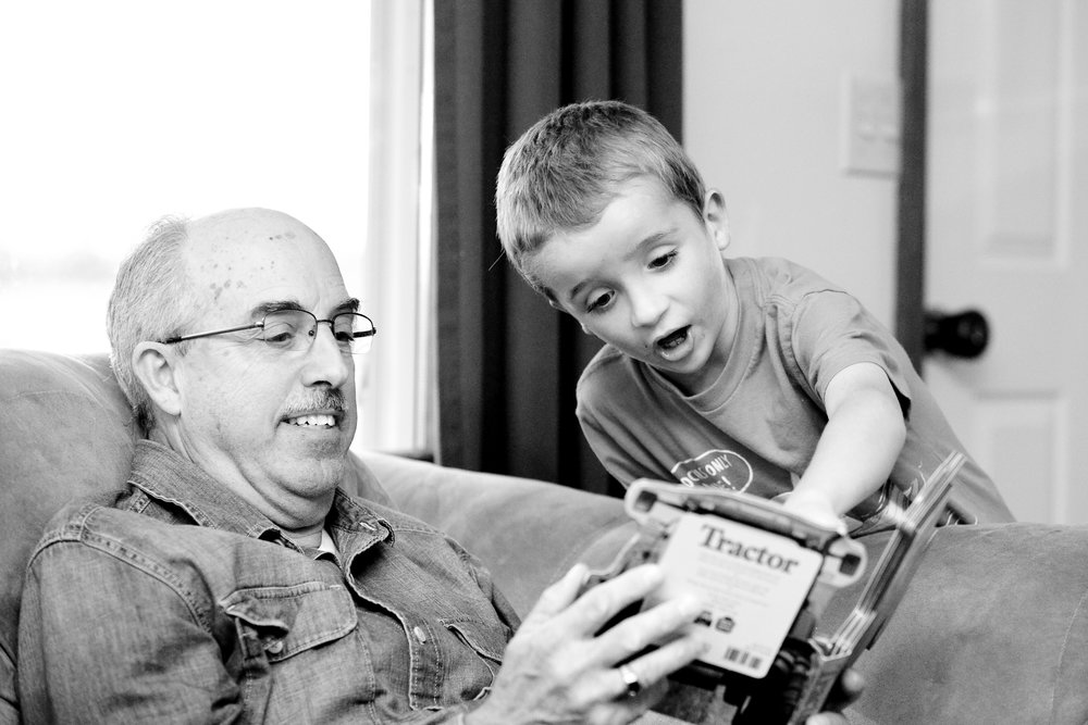 Ein älterer Mann liest einem Kind aus einem Buch vor