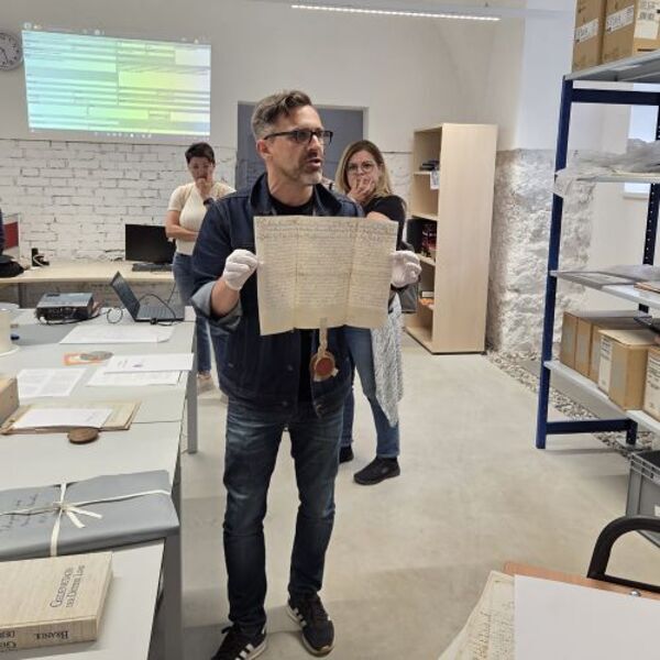 Archivdirektor Klaus Birngruber zeigt den äußerst interessierten KollegInnen eine Urkunde mit Sigel