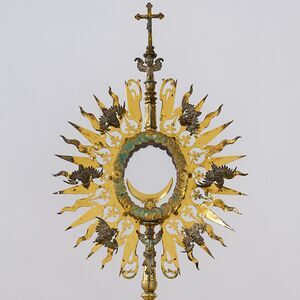 Die Monstranz  stammt aus der Zeit 1630-1640 und ist Silber vergoldet. Hinweis auf die Datierung ist das Augsburger Beschauzeichen 'GE' (Georg Ernst). Ihre Besonderheit ergibt sich durch die Gestaltung mit Cheruben, Engeln, die in der biblischen Über