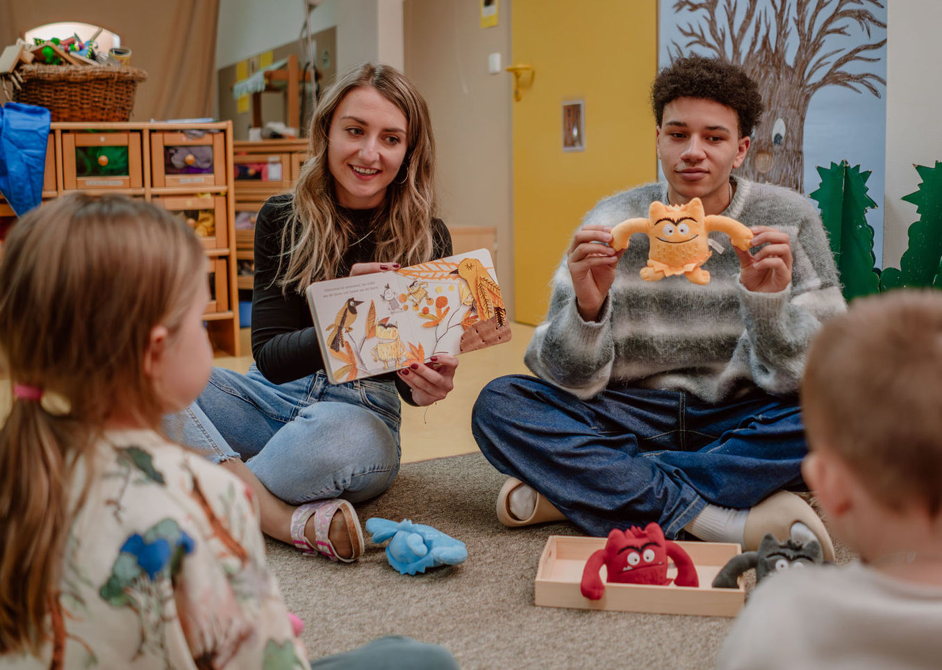 Im Praxiskindergarten der Don-Bosco-Schwestern erzählen Lisa Voraberger und der Drittklässler Julian Wesby den Kindern eine Geschichte.