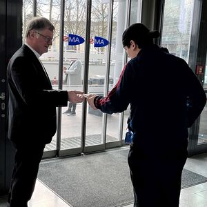 Bischof Scheuer teilt Kekse an arbeitssuchende Menschen aus