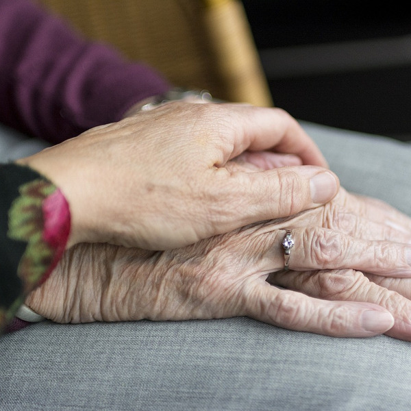 Eine Hand, sanft auf eine andere Hand gelegt.