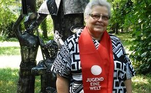 Schwester Hildegard Litzlhammer vor einer Statue von Don Bosco.