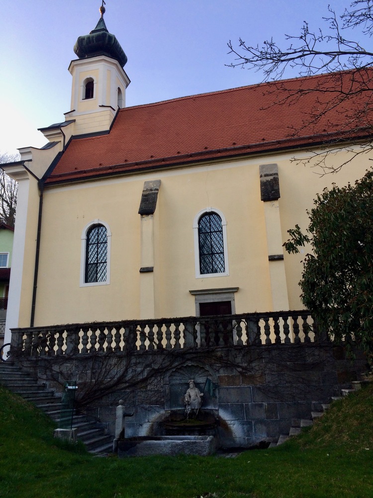 Die Kirche St. Johann in St. Florian bei Linz  mit dem berühmten Brunnen.