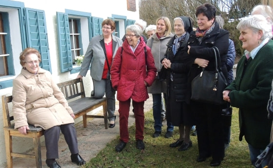 Tochter Rosalia vor dem Jägerstätter-Haus mit den Gästen aus Linz.