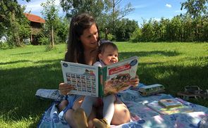 Mama liest Kind aus Bauernhof-Buch vor