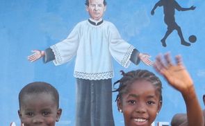 Lachende Kinder vor einem Don Bosco Wandbild in Sierra Leone