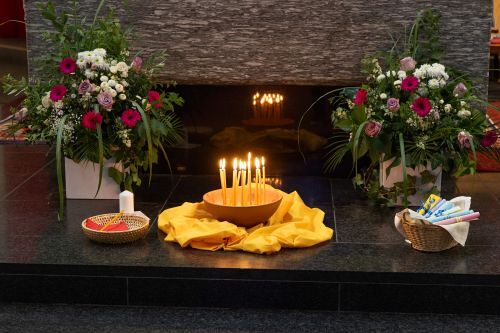 Blumen und Kerzen vor Altar