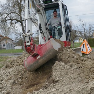 Christoph Birbaumer von  der Fa. Green Expert formt aus Erdhaufen  Böschungen.