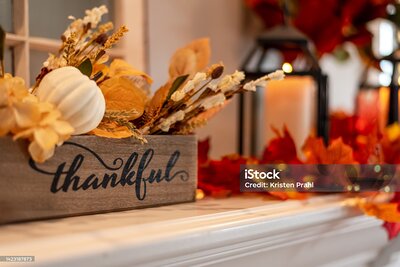 Mantel decorated for fall with autumn leaves and twinkling lights